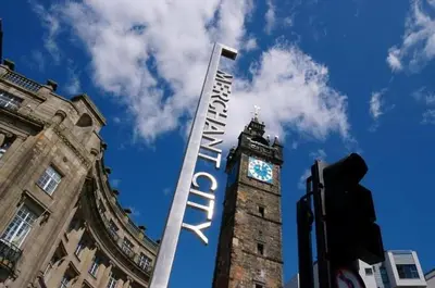 a large sign in front of a building with a clock tower at Merchantcityflat in Glasgow