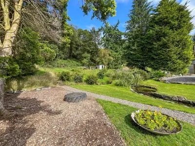 a garden with a tire in the grass at Birch - Apartment in Aberfoyle