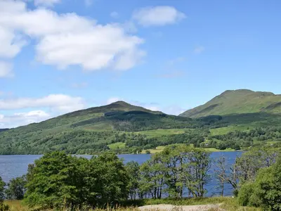 a view of a lake with mountains in the background at Birch - Apartment in Aberfoyle