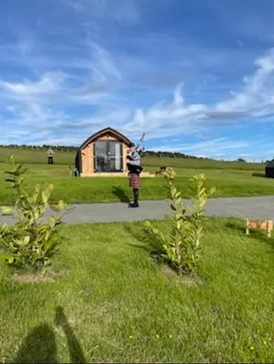 a person is flying a kite in front of a house at Hare's Warren in Bathgate