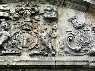 a building with a stone wall with a clock on it at Craigiehall Temple in Edinburgh