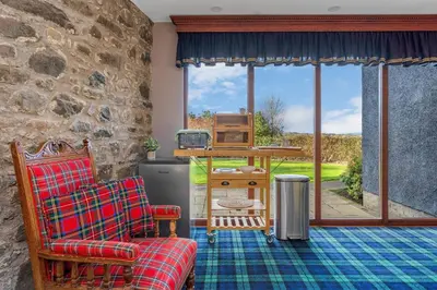 a living room with a couch and a tv at Craigiehall Temple in Edinburgh