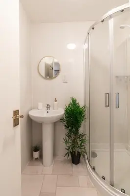 a white bathroom with a sink and a shower at Finnieston 1-Bed - Walk to Hydro & Bars - Sleeps 2 in Glasgow