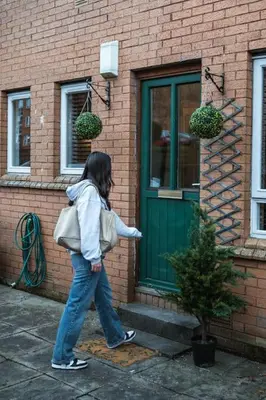 a woman walking in front of a building at Finnieston 1-Bed - Walk to Hydro & Bars - Sleeps 2 in Glasgow