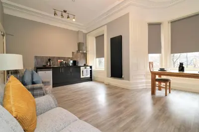 a living room with a couch and a wooden table at Signature - Linden House Flat 3 in Airdrie