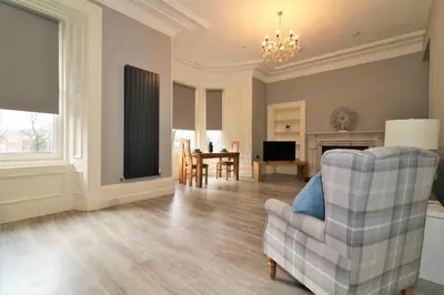 a living room with a couch and a chair at Signature - Linden House Flat 3 in Airdrie