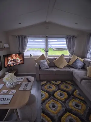 a living room with a couch and a table at 3 bedroom Caravan Craigtara in Ayr