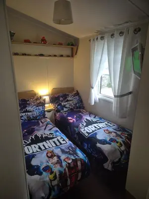 a bedroom with two beds and a window at 3 bedroom Caravan Craigtara in Ayr