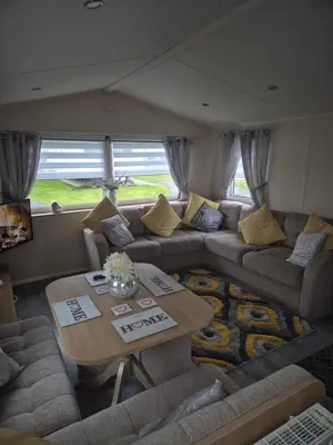 a living room with a couch and a table at 3 bedroom Caravan Craigtara in Ayr