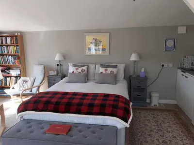 a bedroom with a bed with a red book on it at The Old School Bike Shed in Stirling