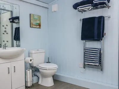 a bathroom with a white toilet and a sink at The Old School Bike Shed in Stirling