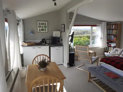 a kitchen and living room with a table and chairs at The Old School Bike Shed in Stirling