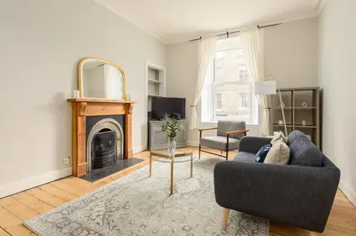 a living room with a couch and a fireplace at The Stockbridge Snug by Calton Living in Edinburgh