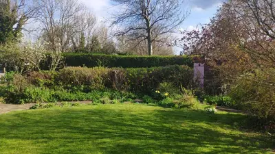a garden with green grass and a hedge at Chilowen - Happy House in Inverkeithing