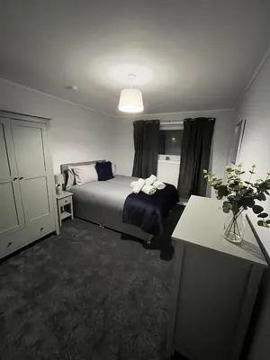 a bedroom with a bed and a table in a room at Breadalbane Apartment in Oban