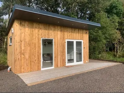 a small wooden building with a black roof at Cruachan Cabin in Oban
