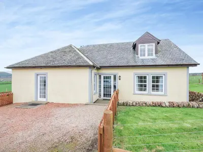 a white house with a fence in front of it at Kerrytonlia Cottage in Mountstuart