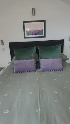 a large bed with two purple pillows on it at Sea Breezes in Oban