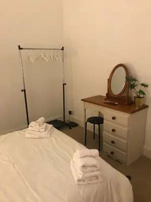 a bedroom with a bed and a dresser and a mirror at Hillview, Ground floor apartment, Largs in Largs