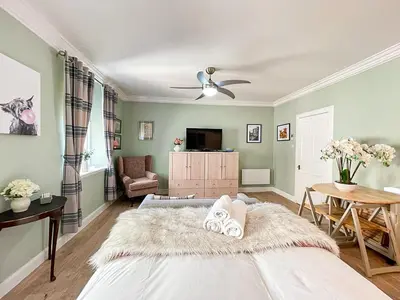a bedroom with a large bed with a white rug at Snug Studio on The Grassmarket, 5mins from Castle in Edinburgh