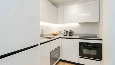 a white kitchen with white cabinets and a sink at PREMIER SUITES Edinburgh Fountain Court in Edinburgh