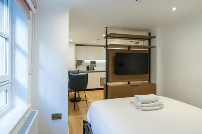 a bedroom with a bed and a television in a room at PREMIER SUITES Edinburgh Fountain Court in Edinburgh