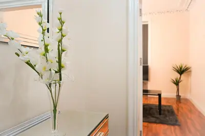 a vase filled with white flowers on a table at Glasgow - 2 Bedroom Apartment in Glasgow