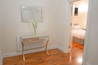 a room with a table with a vase of flowers on it at Glasgow - 2 Bedroom Apartment in Glasgow