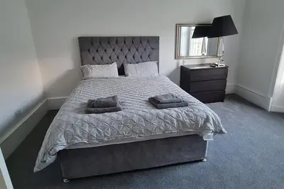 a bedroom with a large bed and a mirror at Large 4 bed (sleeps 8) Castle View in Edinburgh
