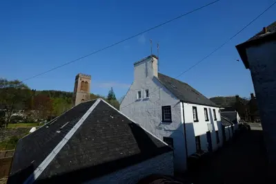 an old white building with a tower on top of it at Cosy cottage flat in Inveraray