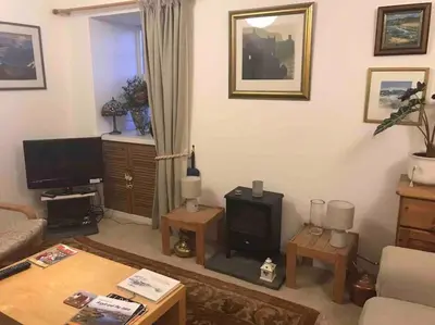a living room with a couch and a tv at Cosy cottage flat in Inveraray