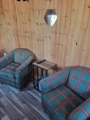 a living room with two couches and a table at Blair snug hut in Kelty
