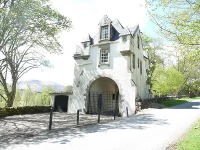 an entrance to a white building with a gate at Gatehouse, Bridge of Balgie, Glenlyon in Bridge of Balgie