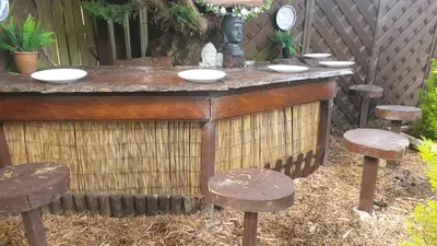 a wooden bar with stools in a backyard at Ceylon HomeStay in Knightswood