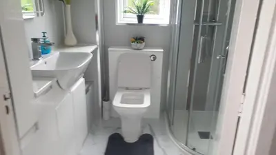 a bathroom with a toilet and a sink and a shower at Ceylon HomeStay in Knightswood