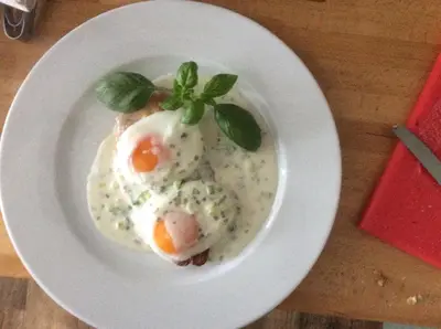a plate of food with eggs on a table at Loch Gorm House in Bruichladdich