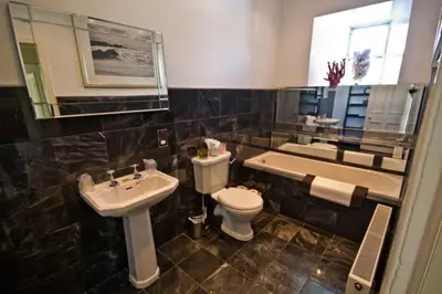 a bathroom with a sink and a toilet and a tub at Loch Gorm House in Bruichladdich