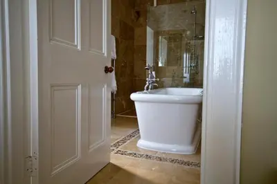 a bathroom with a white tub and a sink at Loch Gorm House in Bruichladdich