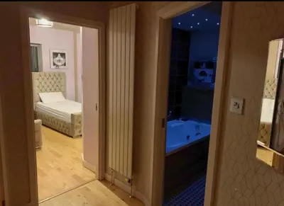 a room with a bathroom with a tub and a bedroom at Designer Penthouse with Riverviews - G1 Glasgow City Centre, 3 Bedrooms, 2 Bathrooms, 1 Living room / Kitchen. Full Floor, Wrap Around Terrace, Panoramic Views, Off Central Station / Buchanan Street in Glasgow