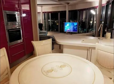 a living room with a table and a television at Designer Penthouse with Riverviews - G1 Glasgow City Centre, 3 Bedrooms, 2 Bathrooms, 1 Living room / Kitchen. Full Floor, Wrap Around Terrace, Panoramic Views, Off Central Station / Buchanan Street in Glasgow