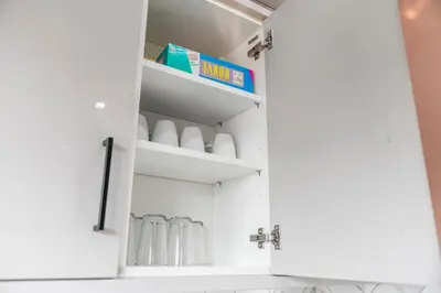 a cupboard with white cabinets and a box in it at Quirky, Family Home in Glasgow in Cardonald