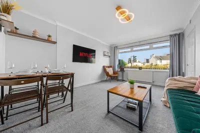 a living room with a table and a couch at Quirky, Family Home in Glasgow in Cardonald