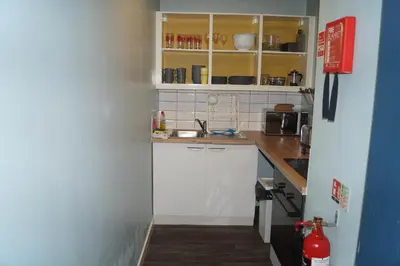 a small kitchen with white cabinets and a sink at Garnock House in Beith