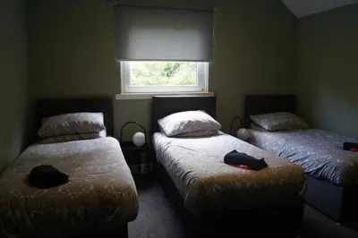 a bedroom with two twin beds and a window at Garnock House in Beith