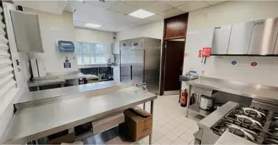 a large kitchen with stainless steel counter tops and appliances at Garnock House in Beith