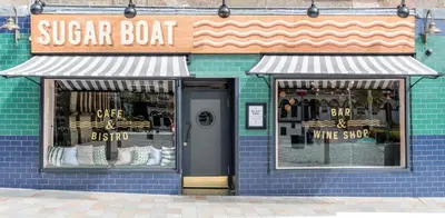 a blue building with a sign for a wine shop at Rooms Above Sugar Boat in Helensburgh