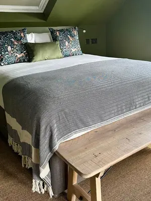 a bed with a wooden bench at the foot of it at Rooms Above Sugar Boat in Helensburgh