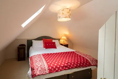 a bedroom with a red and white bed in a attic at The Bothy, Gallin, Glenlyon, Perthshire in Bridge of Balgie