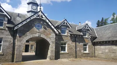 an old stone building with a clock tower on top at The Bothy, Gallin, Glenlyon, Perthshire in Bridge of Balgie