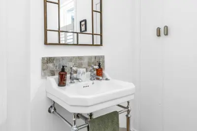 a bathroom with a white sink and a mirror at Beeswing, a Victorian Gem in Biggar in Biggar